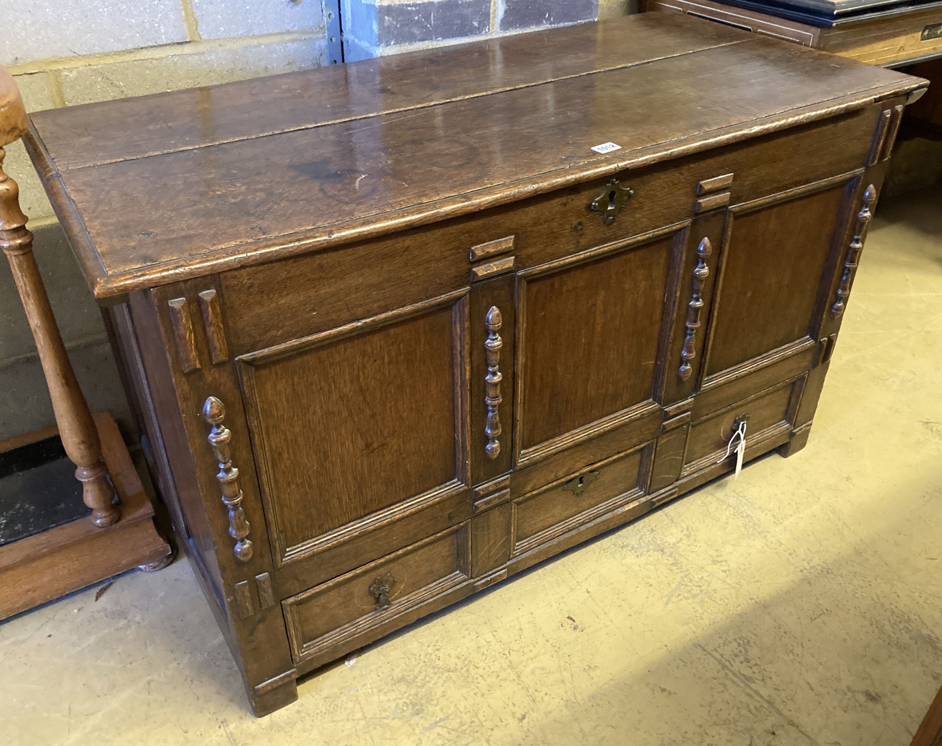 An 18th century panelled oak mule chest with planked top, length 118cm, depth 55cm, height 68cm